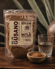 Gran Mitla Sal de Gusano 1kg bag styled with a mezcal glass and agave plant — traditional Oaxacan worm salt for mezcal