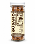 A glass jar of Gran Mitla Sal de Gusano (Agave Worm Salt) on a solid white background. The jar contains brown segmented salt, with a cream-colored label featuring brown text and borders, and a white screw cap.