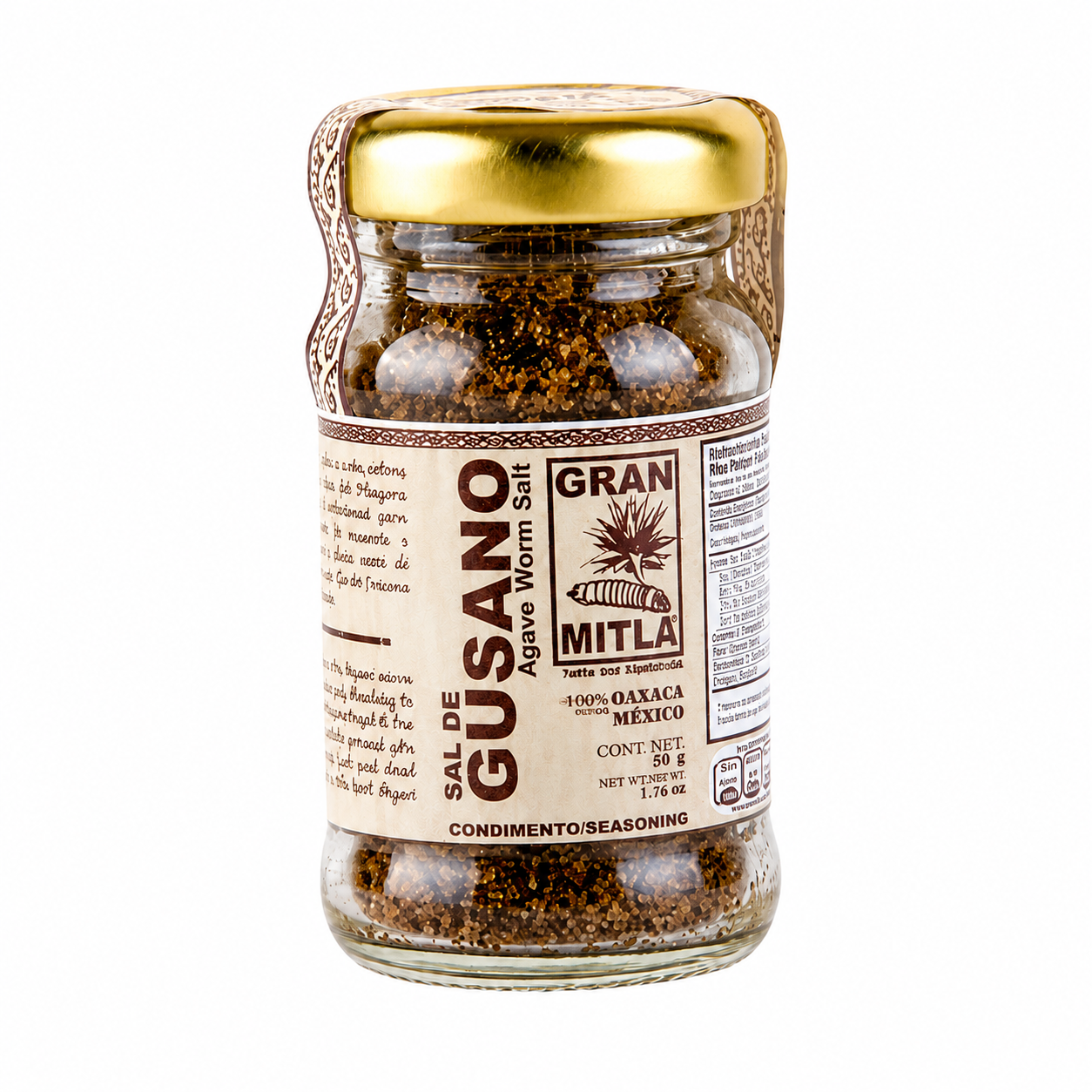 A glass jar of Mitla Gran Sal de Gusano (Agave Worm Salt) with a gold metal lid and a beige label, shown on a solid white background.